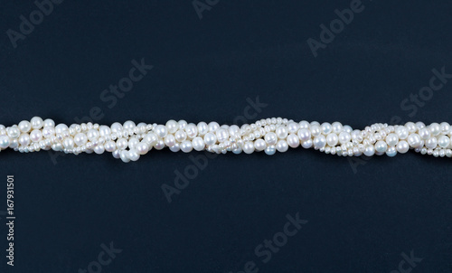 White pearl necklace on the dark background © Elena
