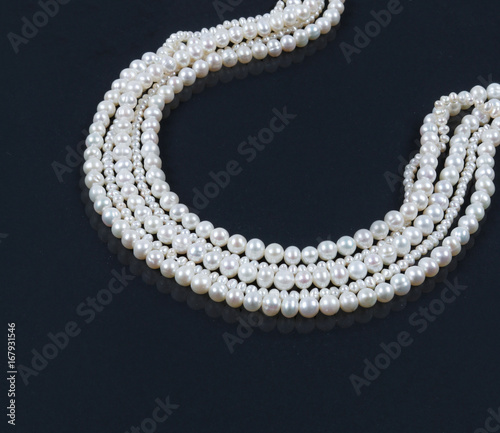 White pearl necklace on the dark background