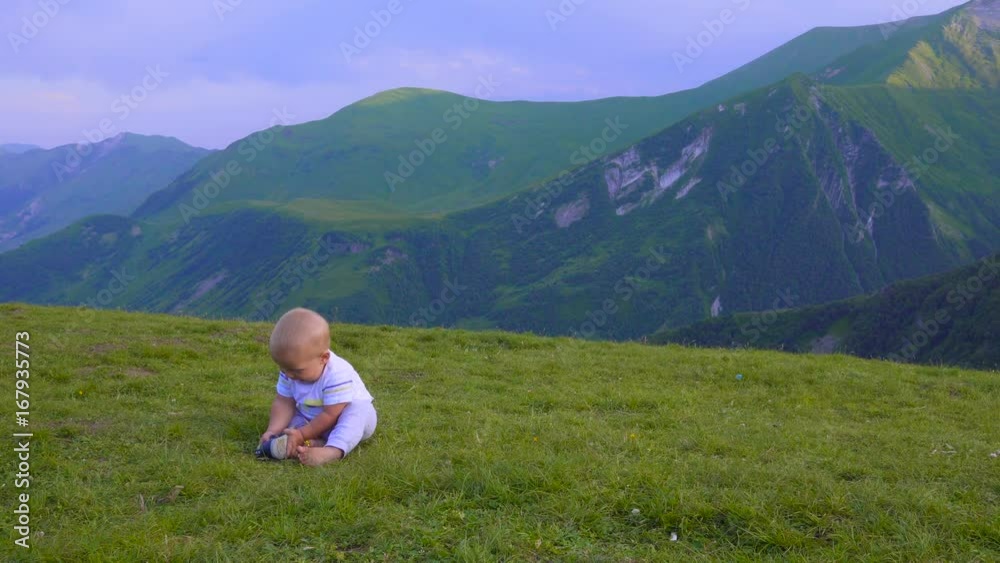 baby is playing in the mountains, sitting and smiling baby is playing in the mountains, sitting and smiling