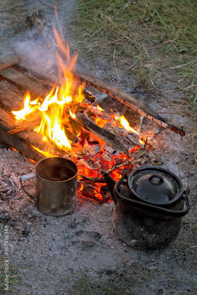 metal mug and teapot near the campfire in the campaign metal mug and teapot near the campfire in the campaign