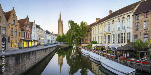 Belgium, West Flanders (Vlaanderen), Bruges (Brugge). Church of Our Lady, Onze-Lieve-Vrouwekerk and buildings along the Dijver canal, at sunset. photo