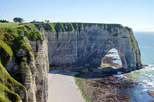 France, Normandy (Normandie), Seine-Maritime department, Etretat. White chalk cliffs and Aiguille d'Etretat, natural stone arch on the coast. photo