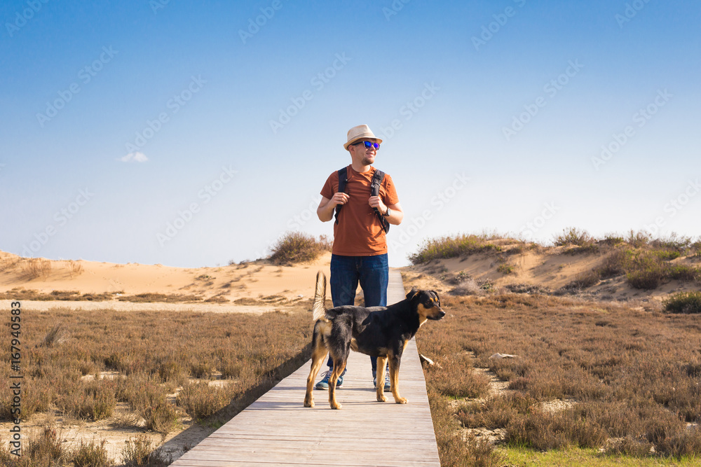 Outdoors lifestyle image of travelling man with cute dog. Tourism concept.