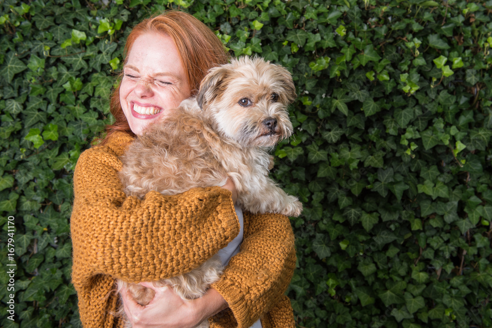 schöne rothaarige Frau hat ihren kleinen Hund auf dem Arm Stock-Foto |  Adobe Stock