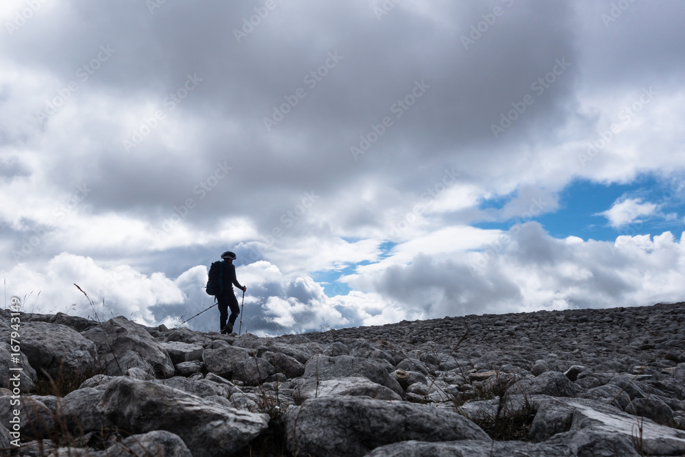 Walker silhouette on rock field on  Scottish Highland Munro