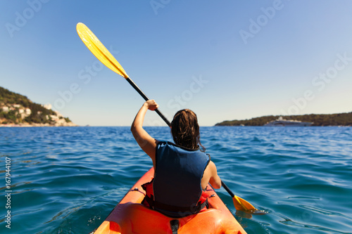 Girl is kayaking on the adriatic sea photo