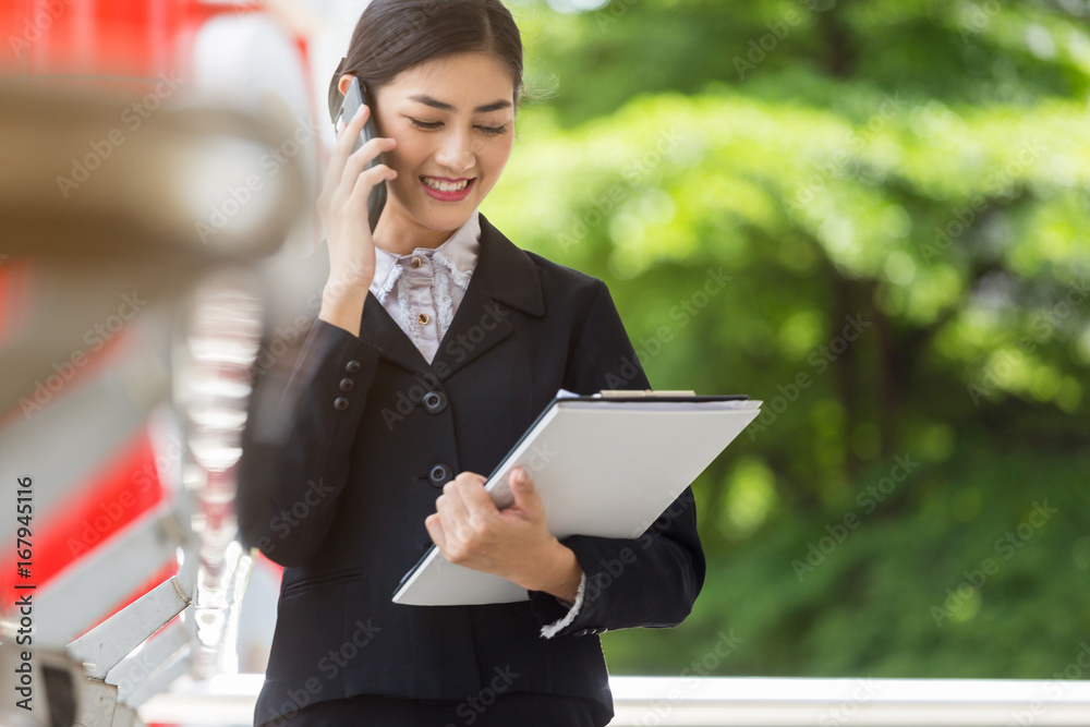 Asian business woman use mobile phone technology talk about working Asian business woman use mobile phone technology talk about working