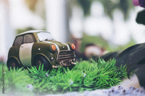 Closeup image of small vintage cars model on green grass