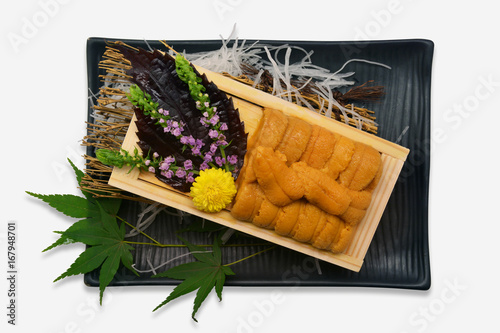 Sea urchin roe in wooden tray Japanese style on black plate and white background (Uni sushi or sashimi ingredients)
