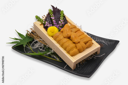Sea urchin roe in wooden tray Japanese style on black plate and white background (Uni sushi or sashimi ingredients) photo