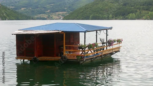 Wooden house floating on river