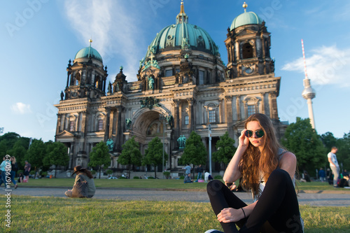 Pretty gil sitting in front of Berlin Cathedral wearing sunglusses photo