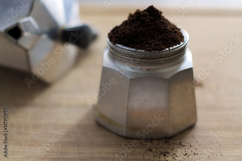 Moka and raw coffee on wood  chopping board