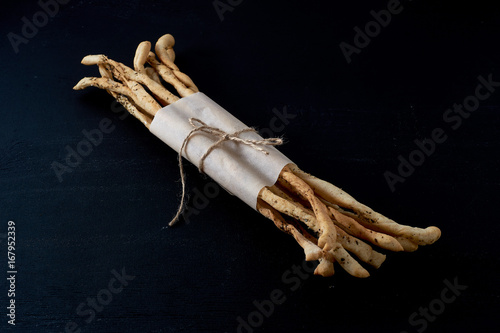 Traditional Italian snack, bread - grissini. On a dark stone table. photo