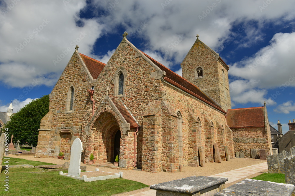 St Lawrence Church, Jersey, U.K. Wide angle image of a partly Medieval building and cemetery in the Summer.