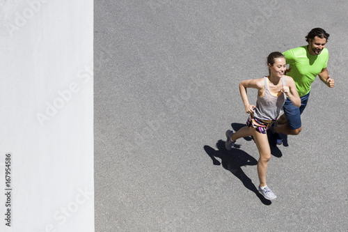 Handsome man and beautiful woman jogging together on street
