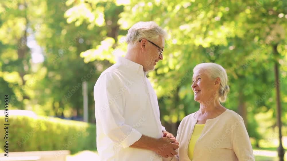 happy senior couple talking at summer city park happy senior couple talking at summer city park