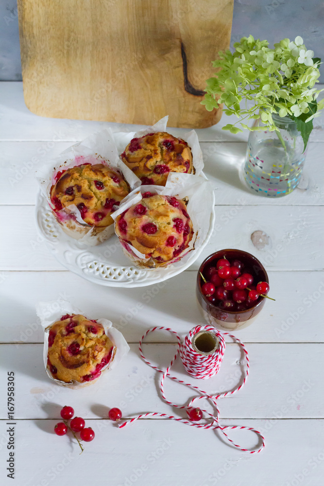 Red currant muffins on white plateau. White wooden table, gray background.  Baking paper. Stock Photo | Adobe Stock