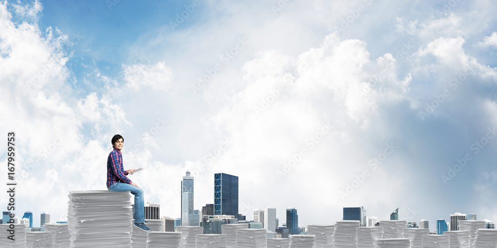 Attractive man sitting on pile of paper documents. Attractive man sitting on pile of paper documents.