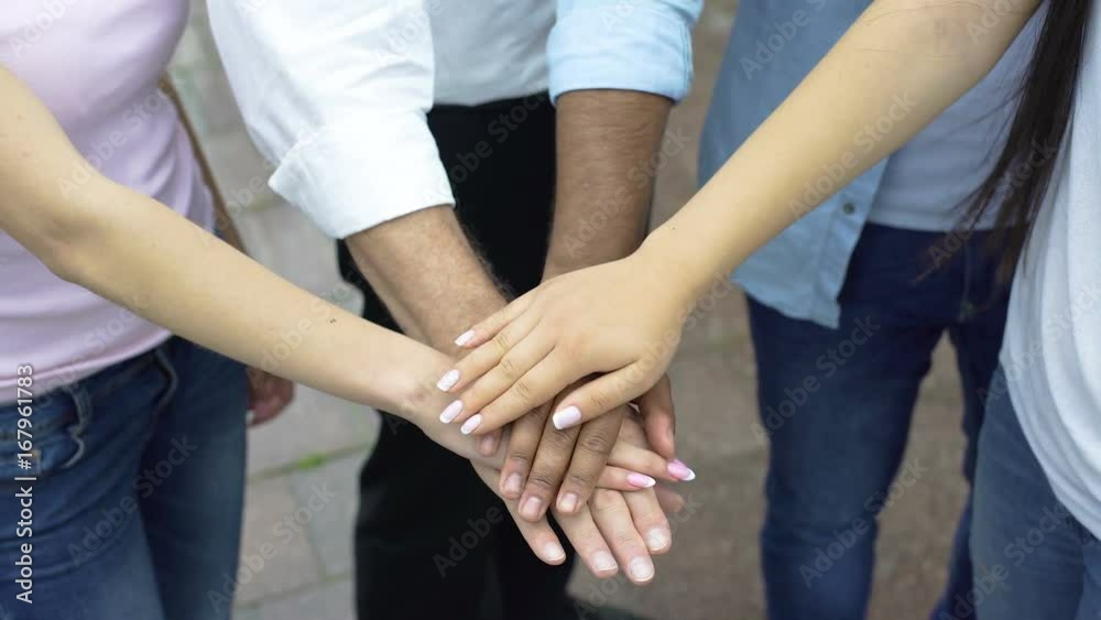 Team spirit of students and teacher, people putting hands on a pile, top view Team spirit of students and teacher, people putting hands on a pile, top view
