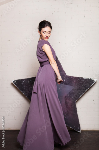 Portrait of a young woman in a long dress in minimalistic loft inteior photo