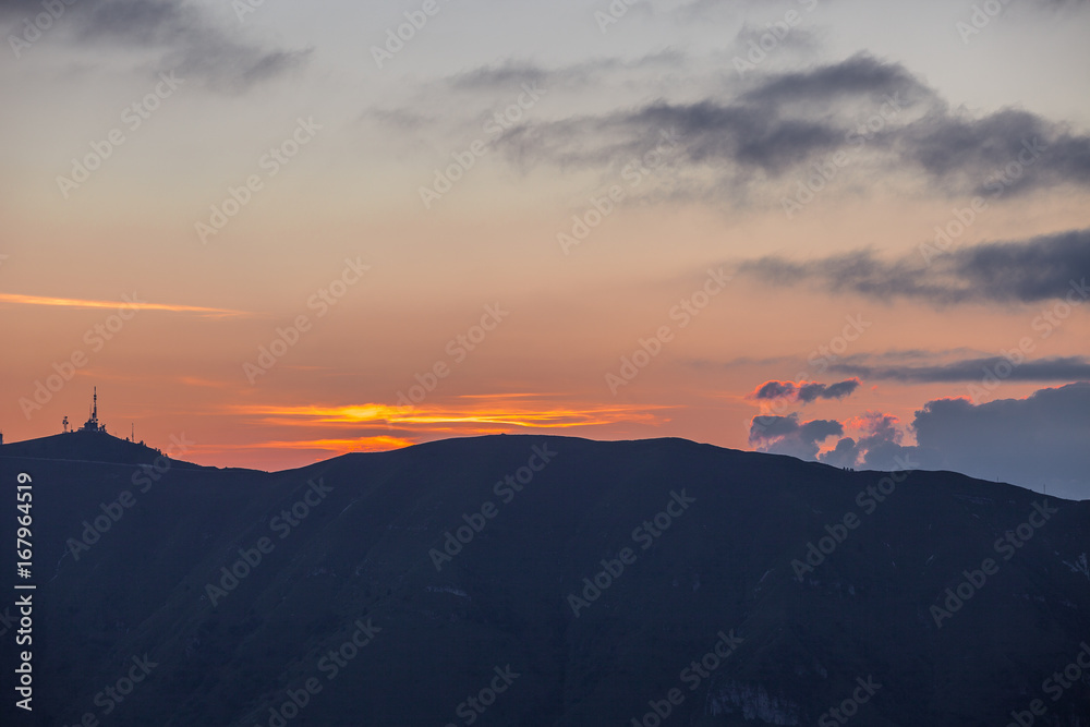 Sunset silhouette with storm in the distance, Cansiglio forest, Veneto, Italy Sunset silhouette with storm in the distance, Cansiglio forest, Veneto, Italy