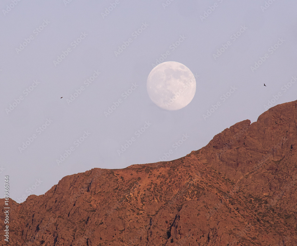 Full moon rises over the mountains of Lumio, Corsica