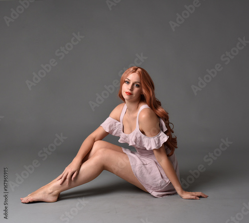 Konstfotografi full length portrait of a pretty girl with long copper hair, wearing a simple purple dress