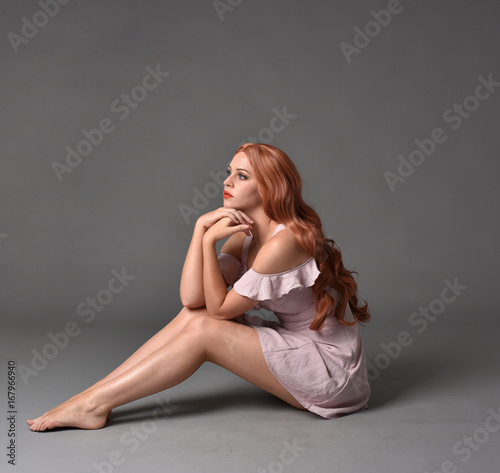 Canvastavla full length portrait of a pretty girl with long copper hair, wearing a simple purple dress