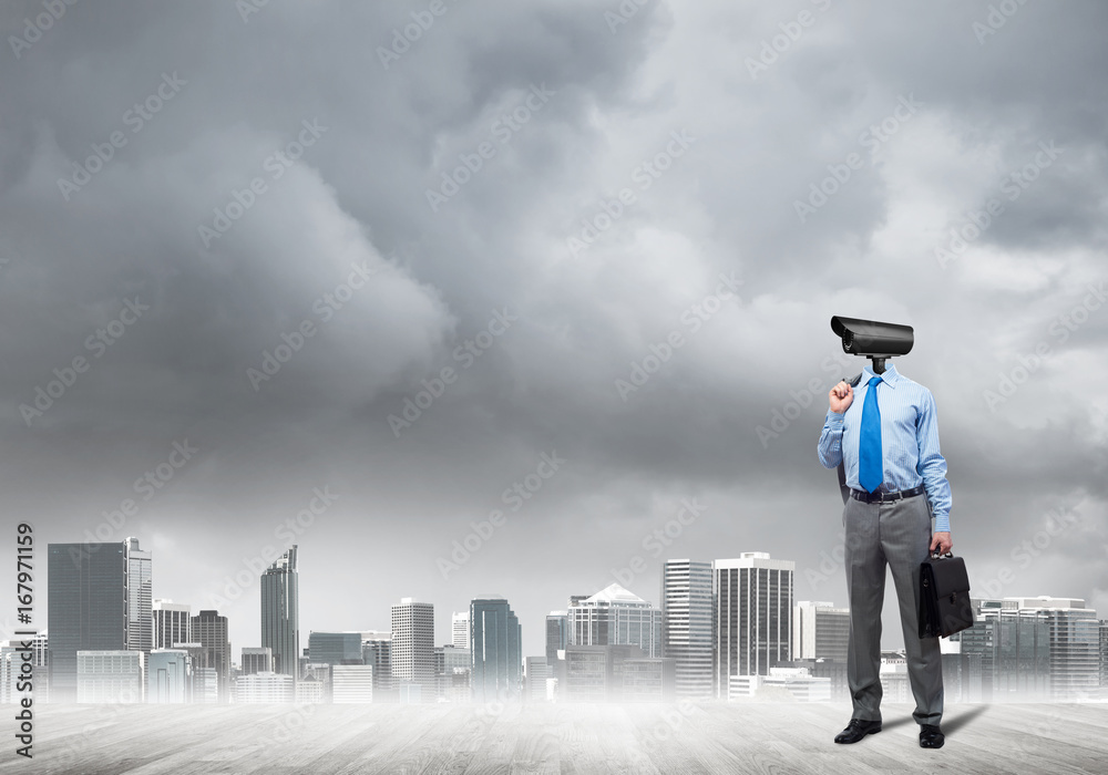 Camera headed man standing on wooden floor against modern cityscape Camera headed man standing on wooden floor against modern cityscape