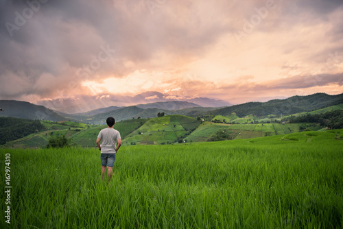 young man enjoying sunset sky in rice field