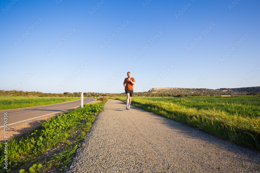 Athletic young man running in the nature. Healthy lifestyle.