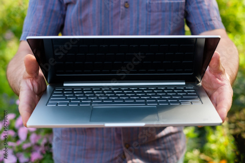 Man holding notebook computer in hands photo