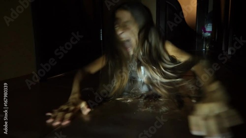 A ghost girl in the house. The spirit of a little girl. Scary scene of a terrible woman. 4k. Slow motion. Something pulls a little girl on the floor