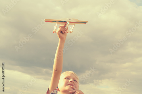 The boy with his hand runs the model of the plane into the sky.