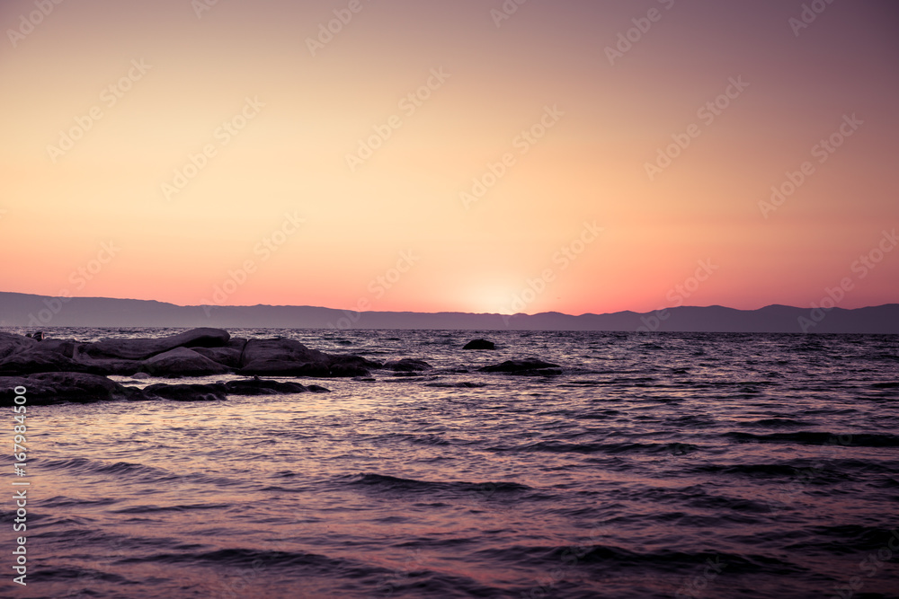 Sunrise horizon / Beautiful beach in Greece while sun rising over the sea