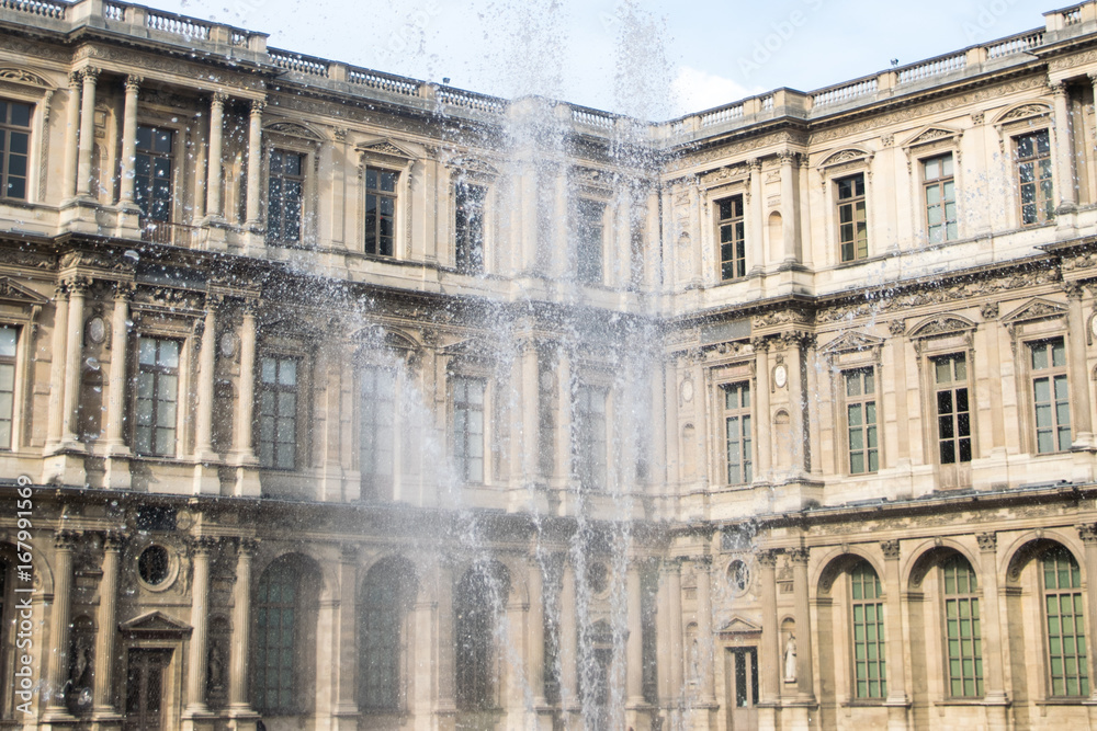 Obraz premium Inner courtyard and exterior of The Louvre Museum with walking tourists in a summer day