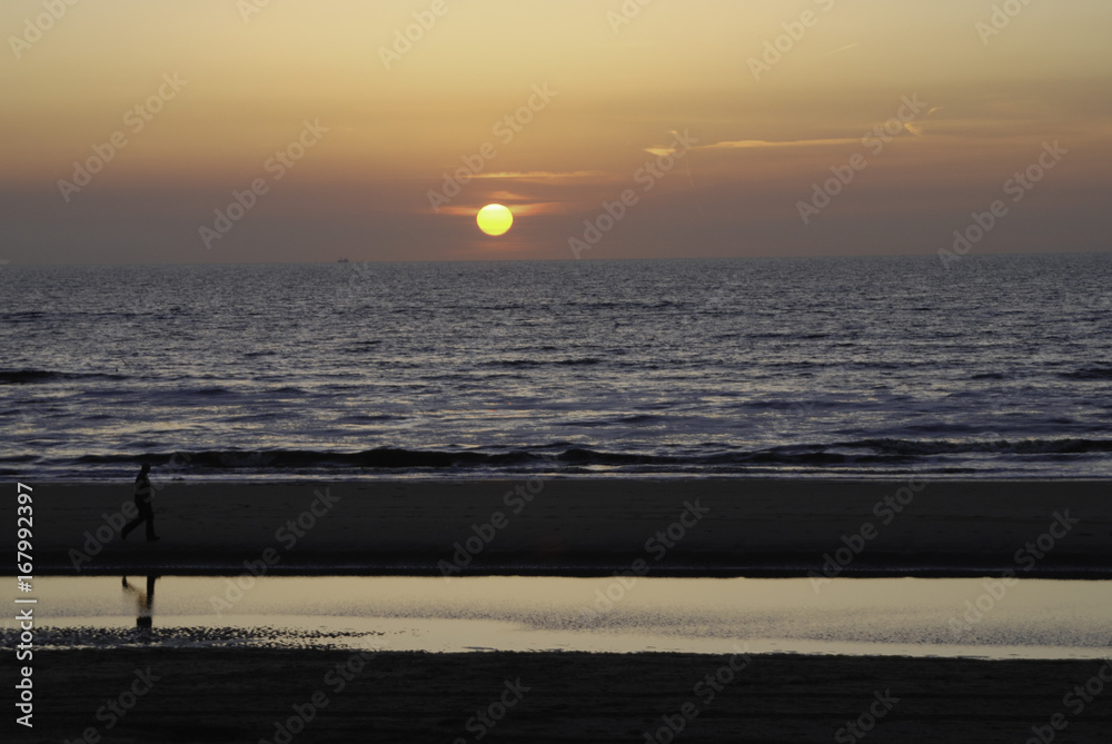 walking along the beach at sunset with reflection