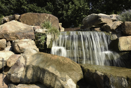small waterfall over boulders front view
