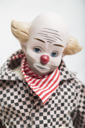 Ceramic porcelain handmade doll of sad clown on white background
