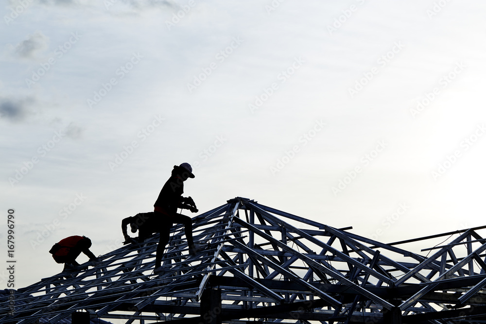 Contractor in Silhouette working on a Roof Top Contractor in Silhouette working on a Roof Top