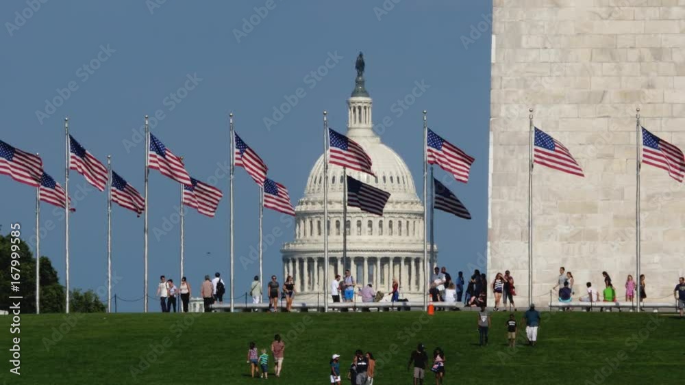 WASHINGTON, D.C. - Circa August, 2017 - A daytime long establishing shot of tourists visiting the Washington Monument with the Capitol Dome in the distance. Shot in 5K.  	