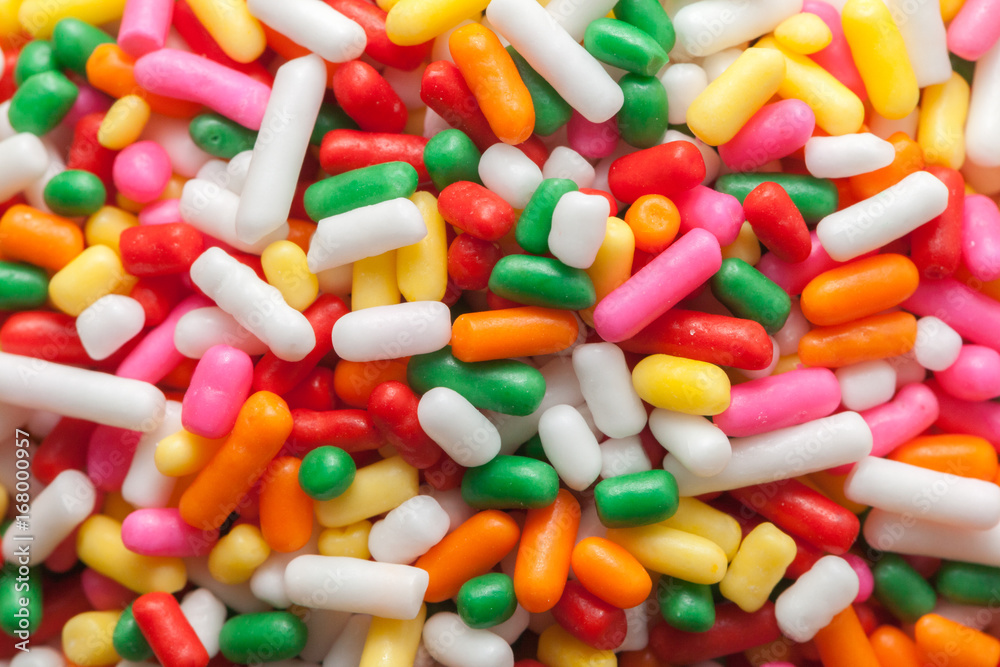 colorful rainbow sprinkles on wooden plate colorful rainbow sprinkles on wooden plate