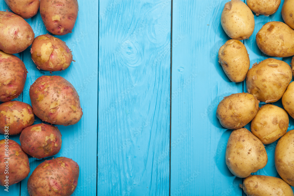 Fresh potatoes on a blue wooden background Fresh potatoes on a blue wooden background