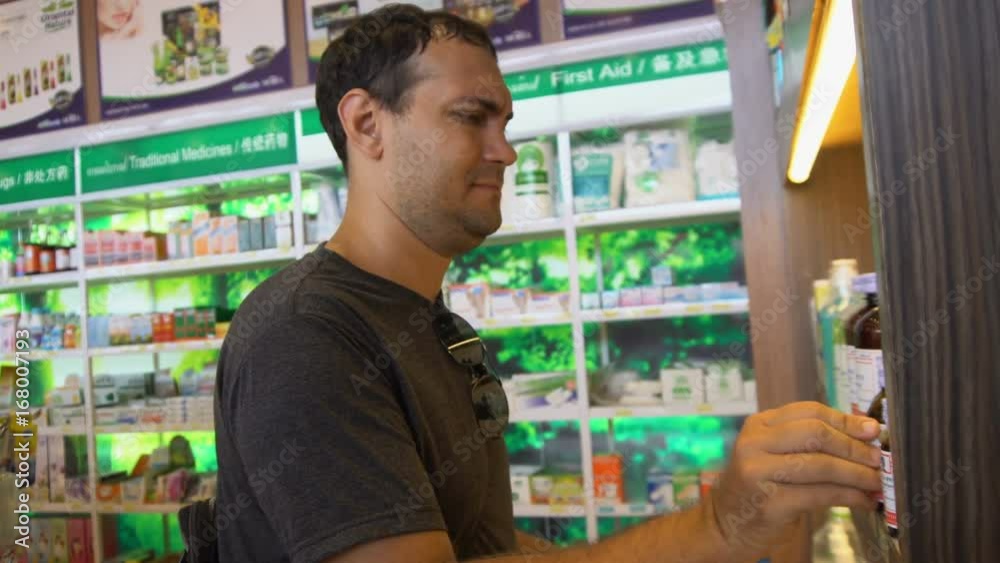 Sick Man Choosing Medicine in Pharmacy Sick Man Choosing Medicine in Pharmacy