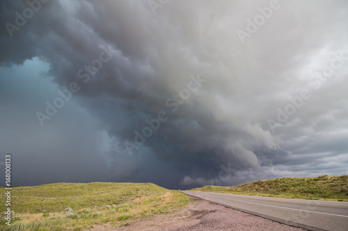 A dangerous thunderstorm rapidly approaches a rural highway in Nebraska.