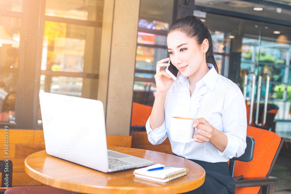 Business women are working on a computer and contacting a mobile phone in an office. Business women are working on a computer and contacting a mobile phone in an office.