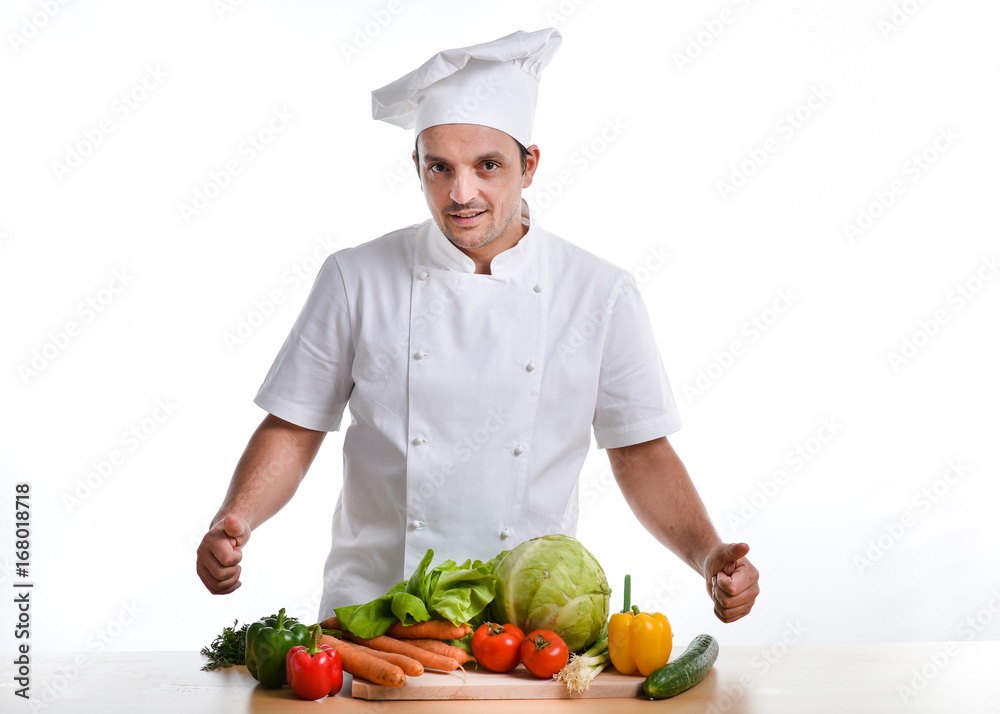 A young chef with vegetables on a wooden board isolated A young chef with vegetables on a wooden board isolated