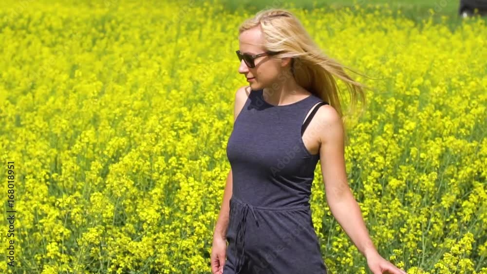 young blonde woman posing in beautiful rapeseed field young blonde woman posing in beautiful rapeseed field