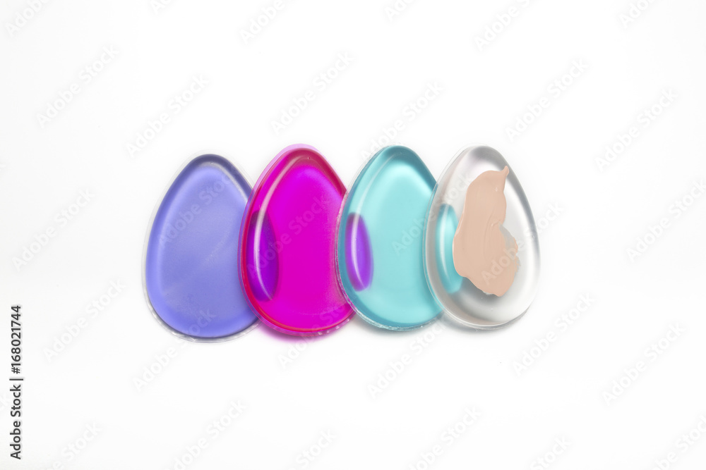 Set of silicone blenders with foundation over a white background Set of silicone blenders with foundation over a white background